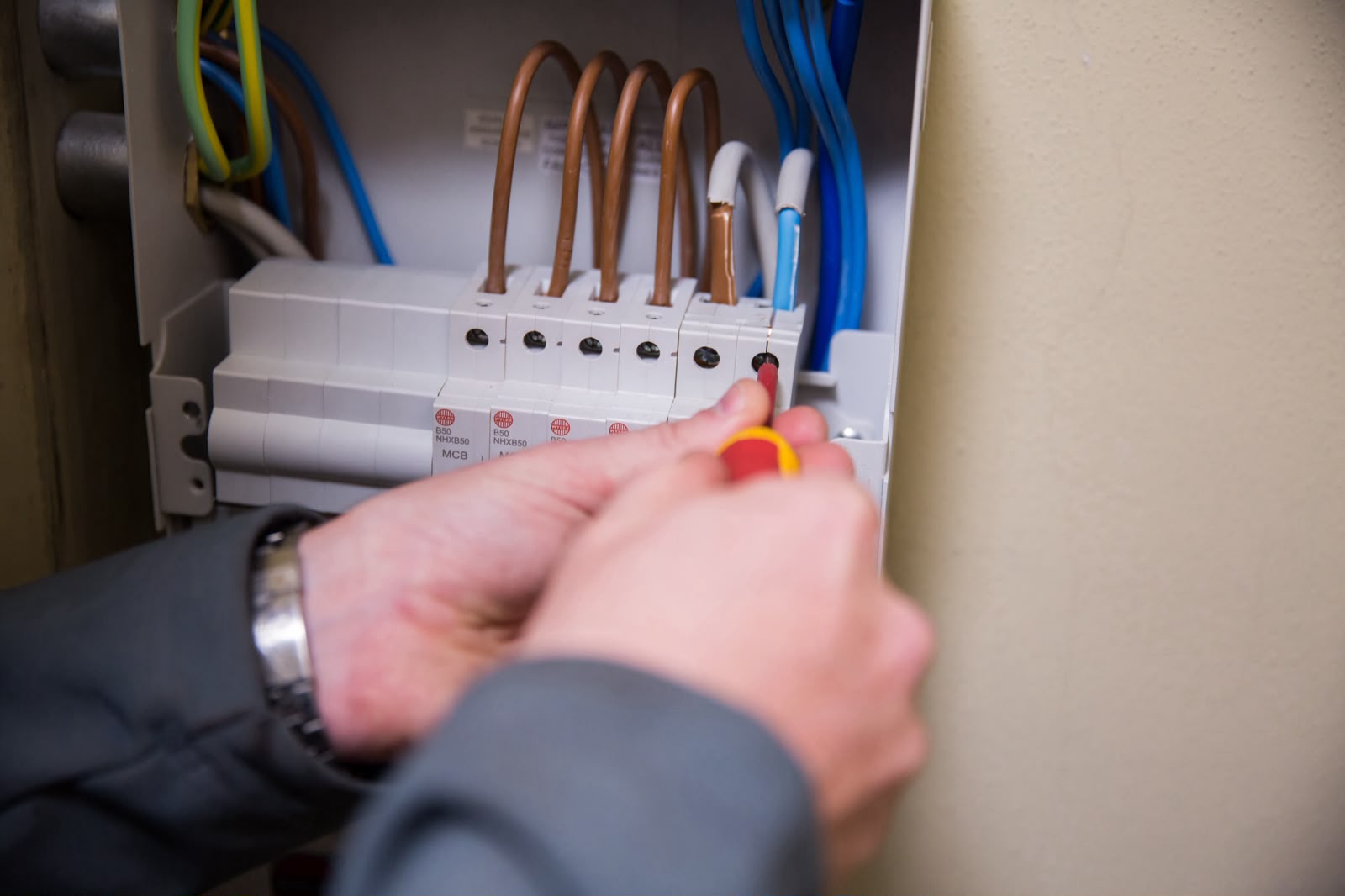 Pyramid Services engineer working inside a consumer unit during remedial works