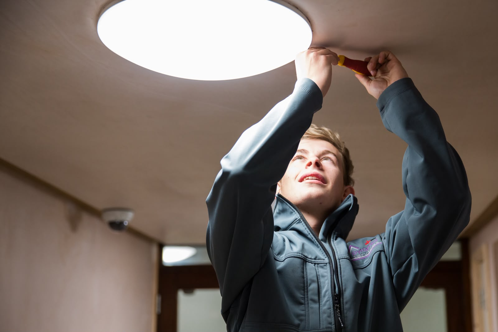A Pyramid Services engineer fitting a ceiling light fitting